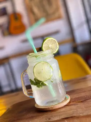 a mason jar filled with a drink with a slice of lime at Bel appartement familial au centre ville in El Kelaa des Srarhna