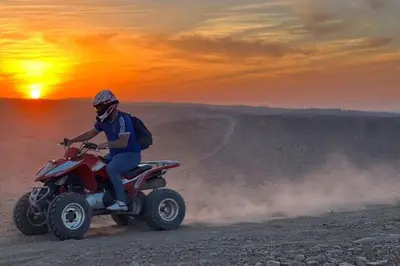 a man riding a quad bike in the desert at sahara camp in Oulad Akkou