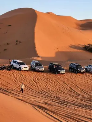a group of cars parked in the desert at Merzouga Nomade Desert Camp in Merzouga