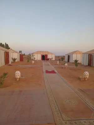 a group of tents in the middle of a desert at Merzouga Nomade Desert Camp in Merzouga