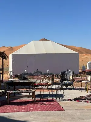 a group of tables and chairs in front of a tent at Finest Luxury Camp in Merzouga