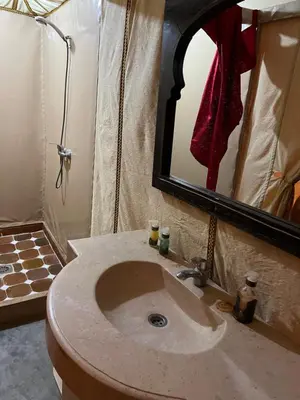 a bathroom with a sink and a mirror at Finest Luxury Camp in Merzouga