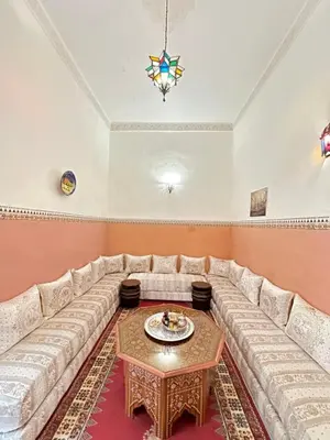 a living room with a large couch and a table at Riad Mounadim Fes -Authentic Riad Luxury Fes in Fès