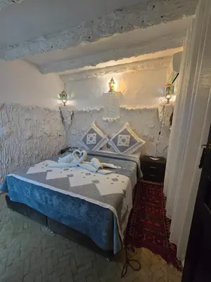 a bedroom with a bed and a chandelier at Riad Mounadim Fes -Authentic Riad Luxury Fes in Fès