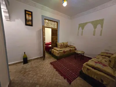 a living room with a couch and a chair at Riad Mounadim Fes -Authentic Riad Luxury Fes in Fès