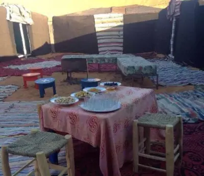 a room with a table with plates of food on it at jumeirah standard camp merzoug in Merzouga