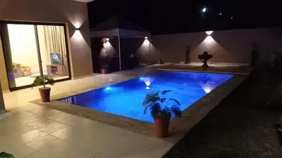 a swimming pool at night with a palm tree in it at Villa jama in Marrakech