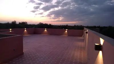 a rooftop of a building with a sunset in the background at Villa jama in Marrakech