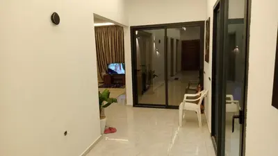a hallway with a white chair and a glass door at Villa jama in Marrakech