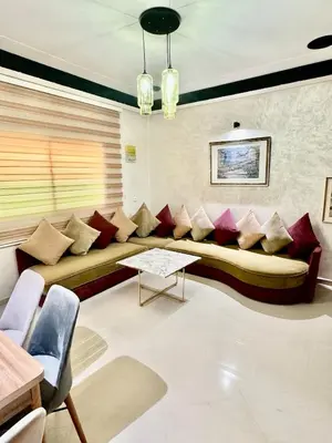 a living room with a large couch with pillows at Apartment, well equipped in Fès