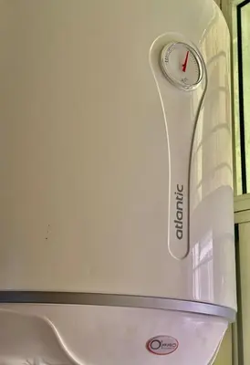 a white refrigerator with a clock on the wall at Apartment, well equipped in Fès