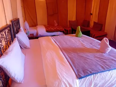 two beds in a room with white sheets at Happy luxury camp in Merzouga