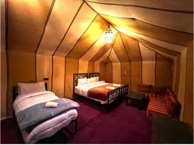 a room with two beds in a tent at Happy luxury camp in Merzouga