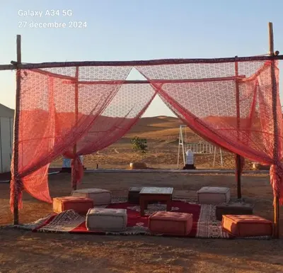 a net with chairs in the middle of a field at Happy luxury camp in Merzouga