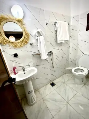 a bathroom with a sink and a toilet and a mirror at Refuge Comfort and Rustic Charm in Anammer
