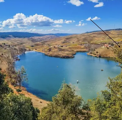 a view of a large lake in a valley at Under Stars Cozy Moroccan Lodge by Lake Ouiouane in Kasba des Aït Athmane