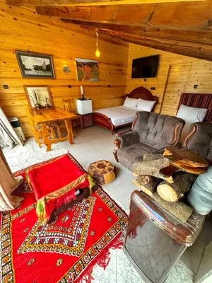 a living room with a couch and a table at Under Stars Cozy Moroccan Lodge by Lake Ouiouane in Kasba des Aït Athmane