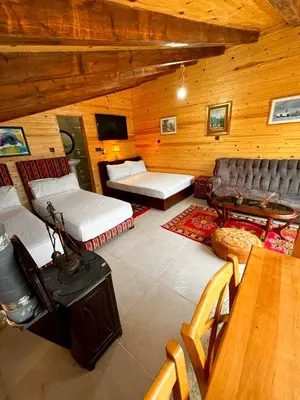 a large room with two beds and a couch at Under Stars Cozy Moroccan Lodge by Lake Ouiouane in Kasba des Aït Athmane