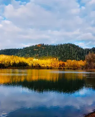a view of a lake with a mountain in the background at Under Stars Cozy Moroccan Lodge by Lake Ouiouane in Kasba des Aït Athmane