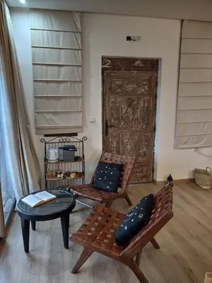 two benches and a table in a room with a door at Auberge laurier rose in Ourika