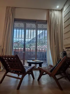 a room with two chairs and a table and a window at Auberge laurier rose in Ourika