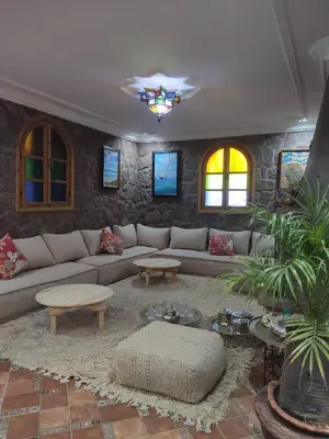 a living room with a couch and tables at Auberge laurier rose in Ourika