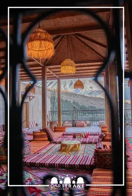 a room with tables and chairs and a painting on the wall at Ecolodge Dar itran in Azilal