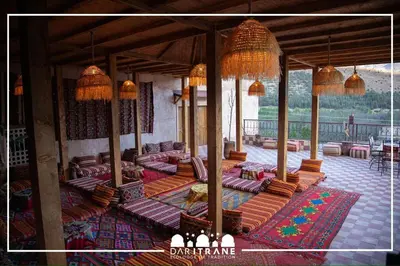 a living room with couches and tables and chandeliers at Ecolodge Dar itran in Azilal