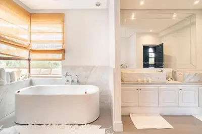 a white bathroom with a tub and a large mirror at Luxury Villa Marrakech - Heated Pool in Najem