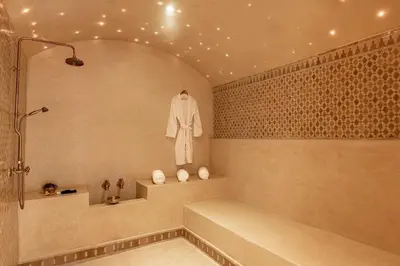 a bath tub with a robe hanging on a wall at Luxury Villa Marrakech - Heated Pool in Najem