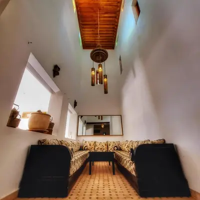 a living room with a couch and a mirror at Dar Muezza in Marrakech