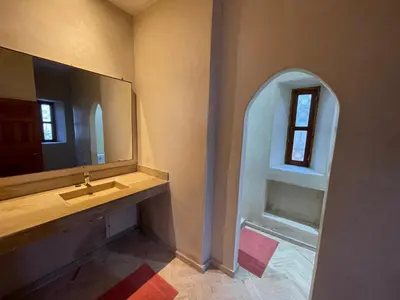 a bathroom with a sink and a mirror and a window at Dar Muezza in Marrakech
