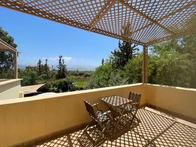 a patio with two chairs and a table on a balcony at Dar Muezza in Marrakech