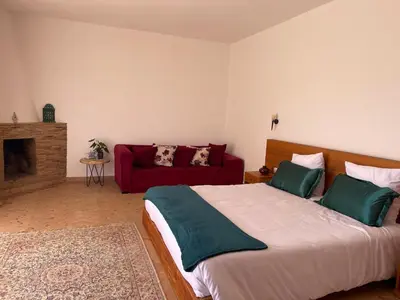 a bedroom with a large bed and a red couch at Dar Muezza in Marrakech