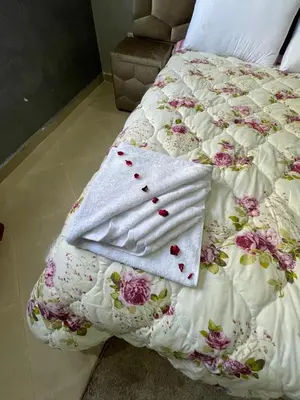 a bed with a white blanket with flowers on it at Deluxe private villa in Marrakech