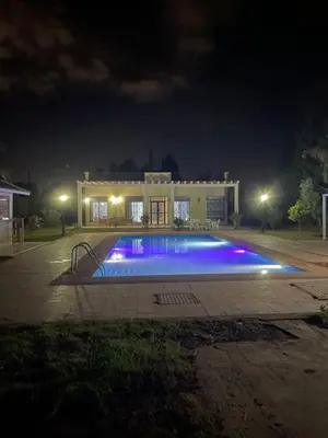 a swimming pool in front of a house at night at Deluxe private villa in Marrakech