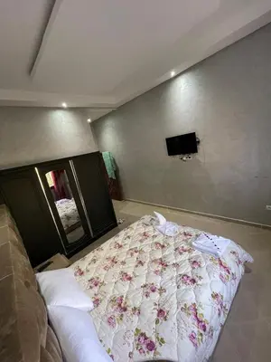 a bedroom with a bed and a tv on the wall at Deluxe private villa in Marrakech