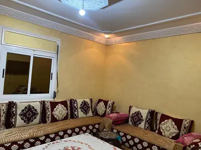 a living room with a couch with pillows and a window at شقة للكراء اليومي in Azrou