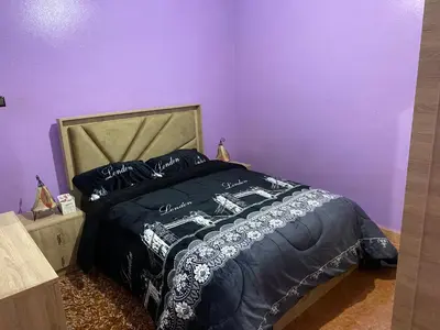 a bedroom with a bed with a purple wall at شقة للكراء اليومي in Azrou