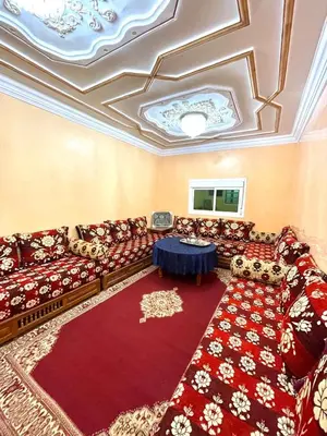 a living room with couches and a red rug at Red Stone Appartement in Midelt