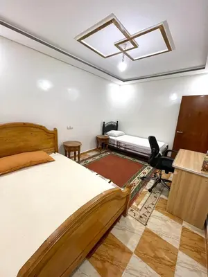 a bedroom with two beds and a skylight at Red Stone Appartement in Midelt