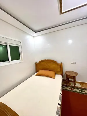 a small bedroom with a bed and a window at Red Stone Appartement in Midelt