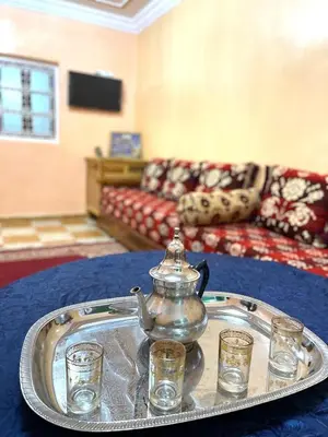 a tray with a tea kettle and glasses on a table at Red Stone Appartement in Midelt