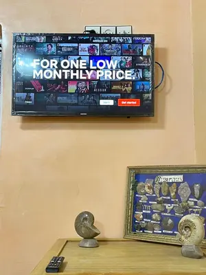 a television hanging on a wall with a game on it at Red Stone Appartement in Midelt