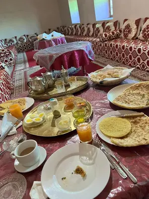a table with plates of food on top at Dar Tamzdamte Skoura in Skoura
