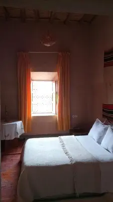 a bedroom with a large bed with a window at Dar Tamzdamte Skoura in Skoura