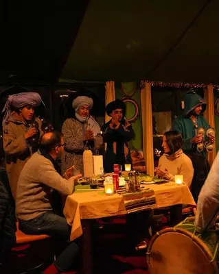 a group of people sitting around a table with candles at Merzouga Sahara Top Camp in Merzouga