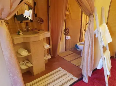 a bathroom with a sink and a toilet in a tent at Tipic luxury camp in Merzouga