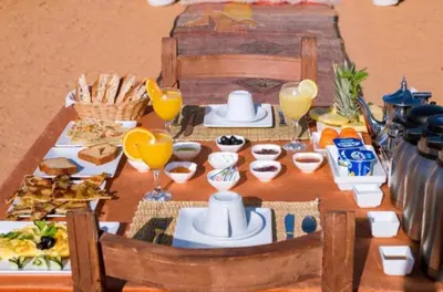 a table with breakfast foods and drinks on it at Tipic luxury camp in Merzouga