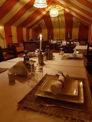 a table with a plate of food in a tent at Tipic luxury camp in Merzouga